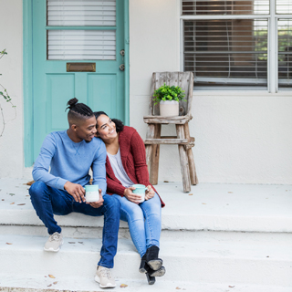 couple in front of house porch