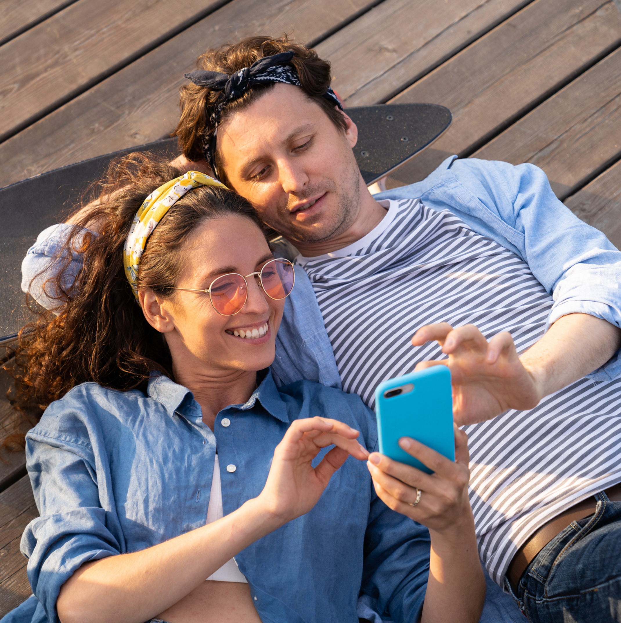 Young couple laying down and enjoying the view on their mobile device