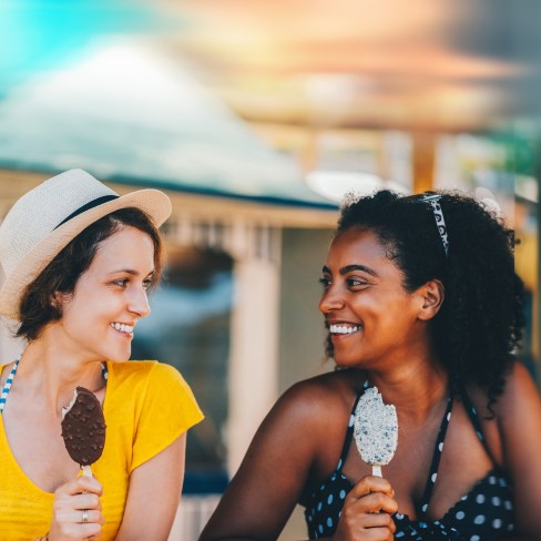 two friends outside enjoying ice cream together