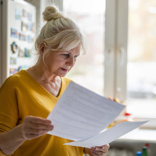 person looking concerned at paper or receipts